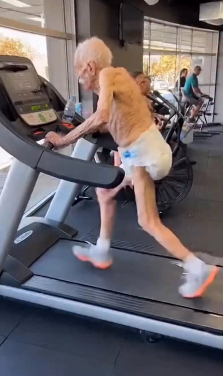 In the middle of a modern gym, surrounded by screens flashing numbers and people chasing speed, strength, and perfection, there was one figure who quietly told a very different story.